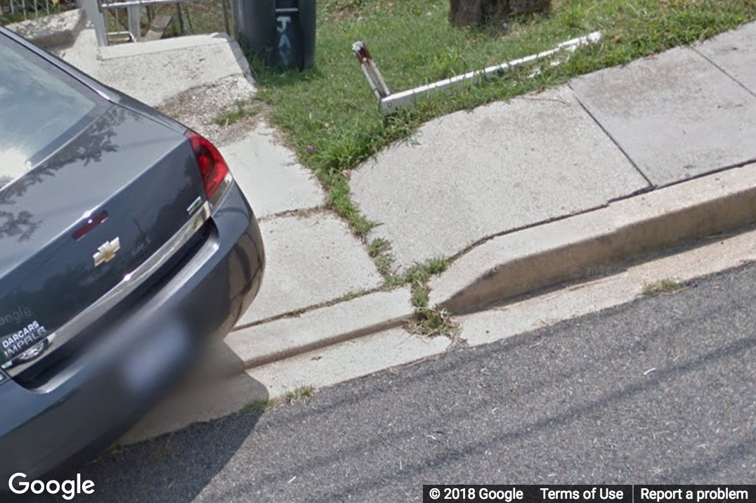 A Street View image of a driveway with a curb ramp