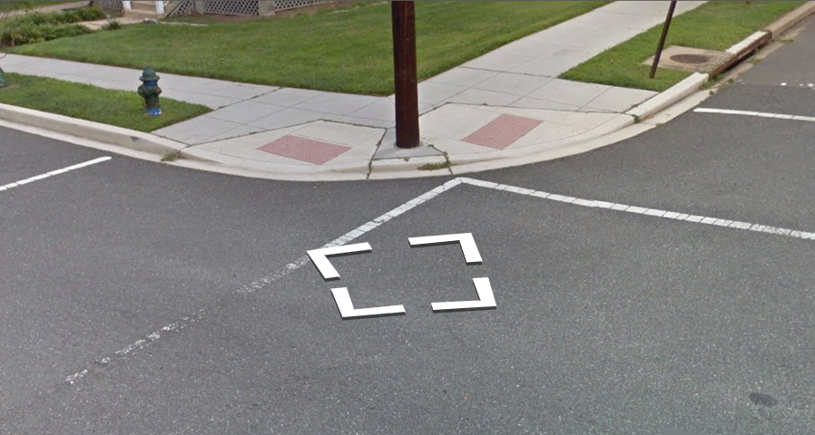 A Street View image of a curb ramp with a tactile warning
