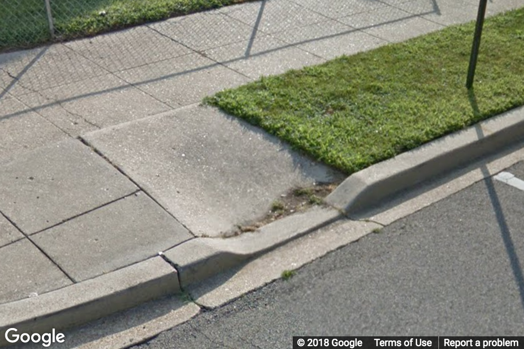 A Street View image of a narrow curb ramp