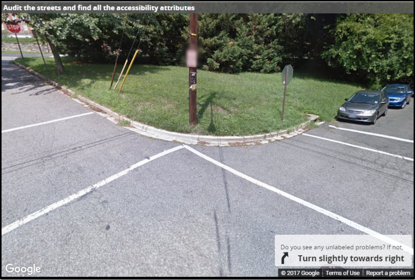 A Street View image of a corner with no curb ramps and no sidewalk