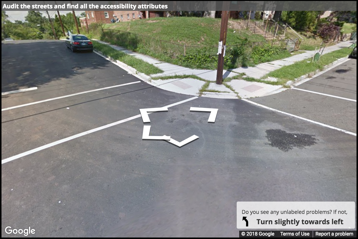 A Street View image of a curb ramp with grass growing on all edges