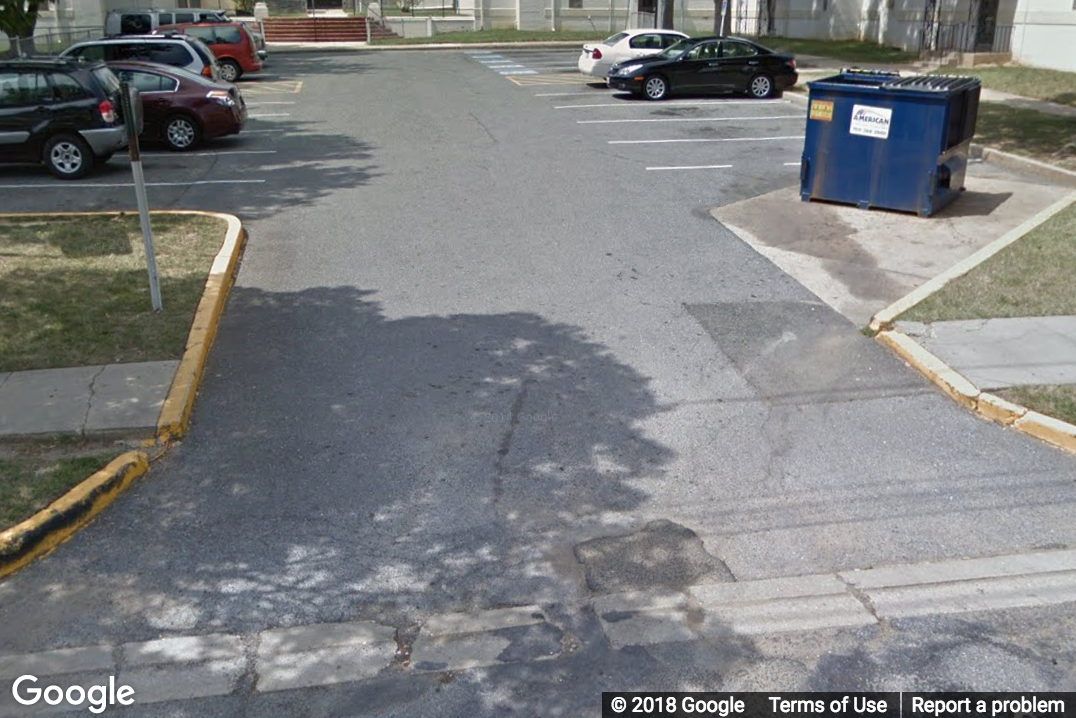 A Street View image of a driveway which causes a steep slope in the sidewalk